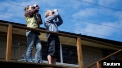 FILE - Cynthia Burrell and husband Jack Seifert, massage therapists whose home-based business has been shuttered in the coronavirus disease outbreak, watch birds from their porch in Seattle, Washington, April 4, 2020. 
