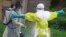 In this photo taken Sept. 9, 2018, a health worker sprays disinfectant on his colleague after working at an Ebola treatment centre in Beni, Eastern Congo.