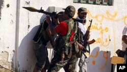 A Libyan rebel fighter prepares to fire a rocket propelled grenade launcher towards a sniper position as they make a final push to flush out pro-Gaddafi forces from the Bab al Aziziya compound in Tripoli, August 24, 2011