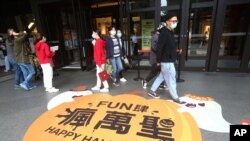 People wear face masks to protect against the spread of the coronavirus as they walk through a shopping district in Taipei, Taiwan, Oct. 29, 2020. 