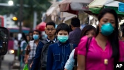 People wearing masks to protect themselves against the swine flu virus in Yangon, Myanmar, July 2017. (AP Photo/Thein Zaw)