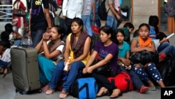 Para perempuan India meninggalkan kota Bangalore karena kekhawatiran akan serangan balasan atas bentrokan etnis di Assam (16/8). 