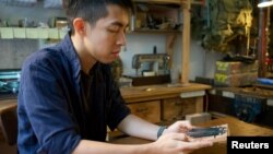 Kevin Cheung, an upcycling product designer, holds a "Glory to Hong Kong" thumb piano that he made using the ribs of umbrellas left over from protests this summer, in Hong Kong, China November 20, 2019. Picture taken November 20, 2019. REUTERS/Sarah Wu