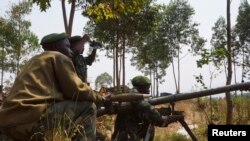 Congolese government army soldiers prepare their weapons at an attack position near Munigi, overlooking the front-line, where they are fighting against M23 rebels outside the eastern Congolese city of Goma, Jul. 15, 2013.