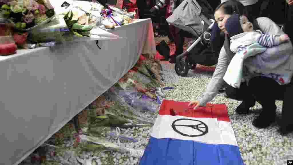 Wata Mata Ta Mika Filawa A Gaban Ofishin Jakadancin Faransa Dake Tokyo, Yayin Da Ake Gudanar Da Addu&#39;oi Dominn Wadanda Harin Da Aka Kai A Faransa Ya Rutsa Da Su, Nuwamba 15, 2015. &nbsp;