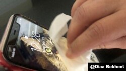 រូបឯកសារ៖ ស្រ្តីម្នាក់លាងសម្អាតទូរសព្ទដៃរបស់ខ្លួននៅ រដ្ឋ Virginia កាលពីថ្ងៃទី២៣ ខែមីនា ឆ្នាំ២០២០។ 