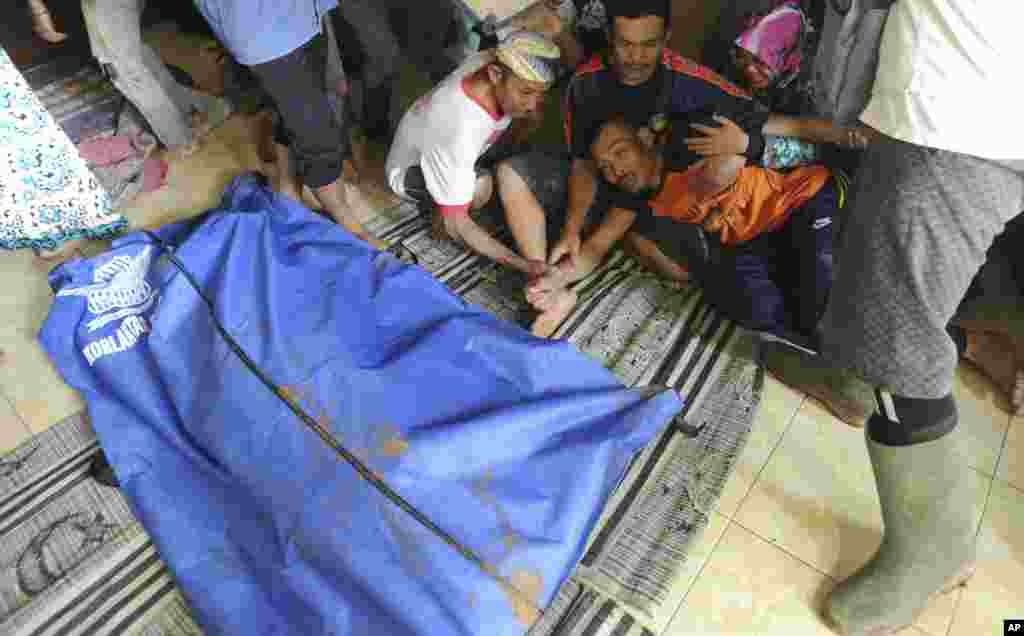 បុរស​ម្នាក់​យំ​សោក​នៅ​ក្បែរ​សព​សាច់ញាតិ​របស់​ខ្លួន​ដែល​ត្រូវ​បាន​ស្លាប់​ដោយ​សារ​ការ​បាក់​ដី​នៅ​ Sirnaresmi ភាគ​ខាងលិចកោះ​ Java​ ប្រទេស​ឥណ្ឌូណេស៊ី។ ការបាក់ដី​ដែល​បង្ក​ដោយ​ភ្លៀង​ធ្លាក់​ខ្លាំង​មួយ​បាន​ស្លាប់​មនុស្ស​ និង​ធ្វើ​ឲ្យ​បាត់​ខ្លួន​ជាច្រើន​នាក់។