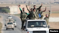 Kombatan pemberontak Suriah yang didukung Turki berkendara dekat perbatasan Kota Tal Abyad, Suriah, 22 Oktober 2019.