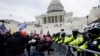 Pendukung Trump mencoba menerobos penghalang polisi di Gedung Capitol, Washington D.C., 6 Januari 2021. (AP Photo/Julio Cortez).