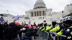 Pendukung Trump mencoba menerobos penghalang polisi di Gedung Capitol, Washington D.C., 6 Januari 2021. (AP Photo/Julio Cortez).