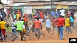 Des manifestants s'enfuient devant la police antiémeute dans un quartier de Conakry, le 21 novembre 2017.