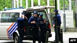 Belgian police stand guard outside, on the sideline of searches conducted at the European Parliament building as part of a Belgian probe into suspected Russian interference and corruption in Brussels on May 29, 2024.