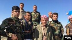 Elder Peshmerga fighter and now a volunteer, Omar Mirhan stands with his fellow Peshmerga on a hill overlooking the area of Makhmour which the Peshmerga won back from Islamic State in 2014, March 8, 2016. (S. Behn/VOA)