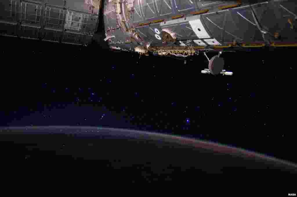 Foto planet Bumi, rasi bintang Orion (bintang Bajak), dan stasiun antariksa internasional (ISS) oleh astronot AS, Reid Wiseman.