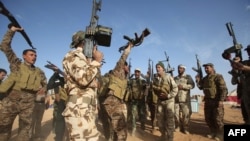 Para pejuang Irak dari unit mobilisasi Muslim Syiah Al-Abbas menyandang senjata di desa Nukhayb, provinsi Anbar (19/5). (AFP/Mohammed Sawaf)