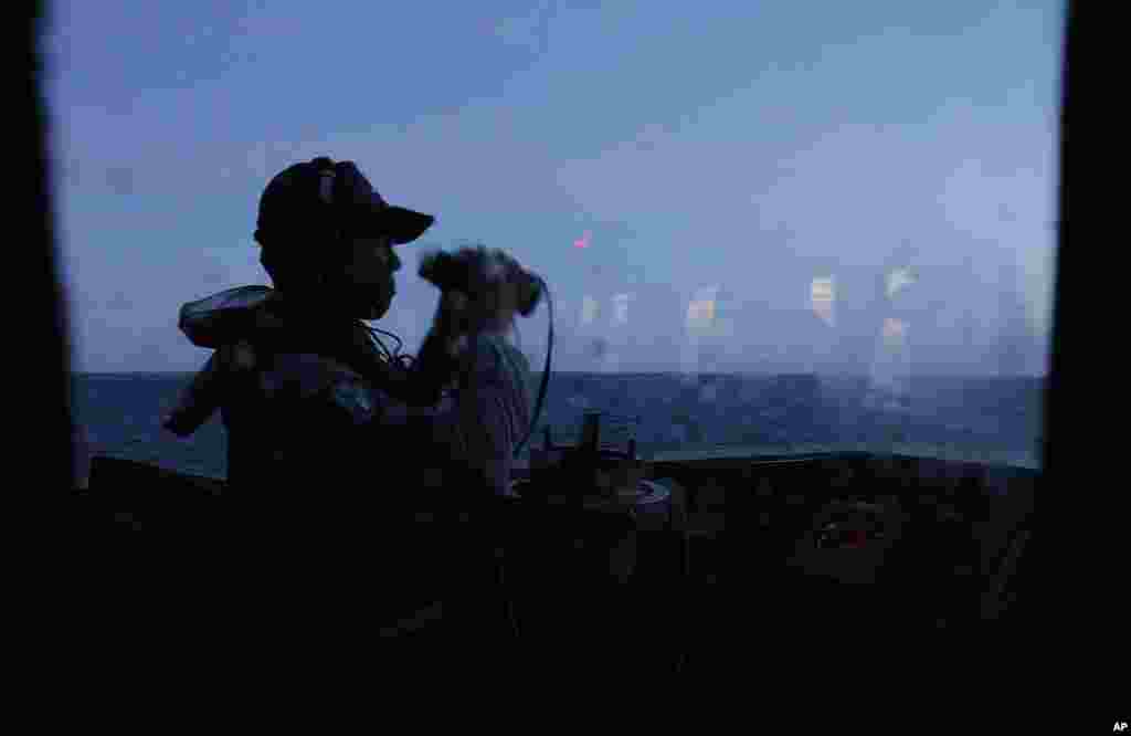 A crew member keeps an eye on the horizon at dawn during exercises off the southern city of Kaohsiung, Taiwan, May 16, 2013. 