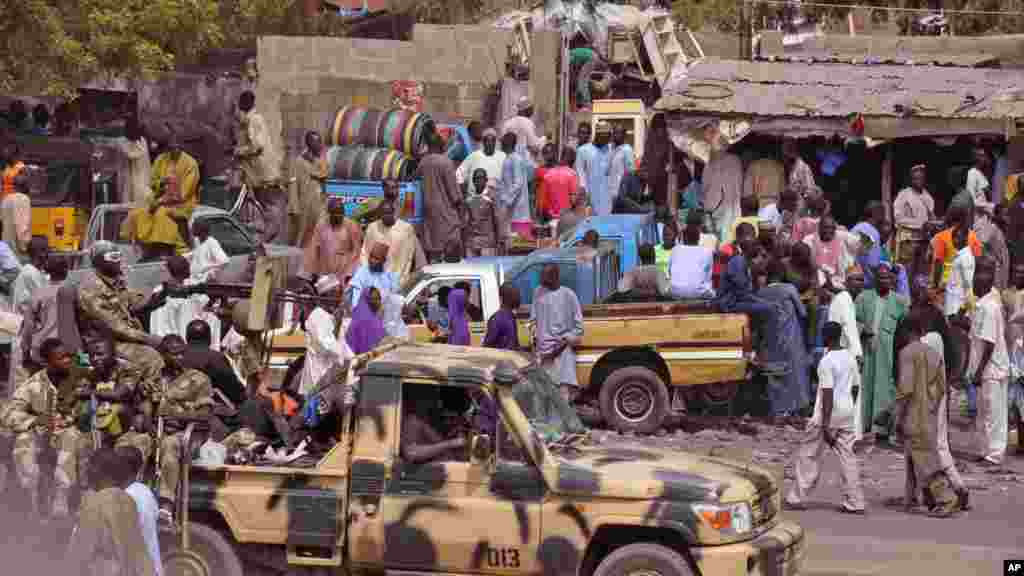 Sojojin Najeriya akan wata motar yaki a lokacin da suke zagaye a wata karamar kasuwa a birnin Maiduguri.