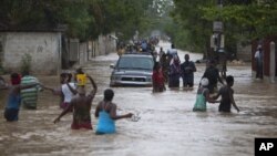 Stanovnici Port-o-Prinsa hodaju preplavljenim ulicama prestonice posle naleta oluje Ajzak