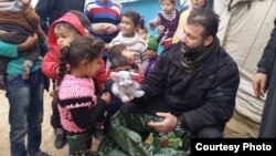 Rami Adham offre des jouets aux enfants syriens dans un camp de réfugiés près de la ville d'Alep déchirée par la guerre en février 2016. (Photo fournie par Rami Adham) 