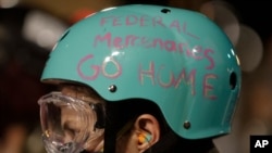 A demonstrator's protective helmet reads "Federal Mercenaries Go Home" during a Black Lives Matter protest at the Mark O. Hatfield United States Courthouse, July 26, 2020, in Portland, Ore. 