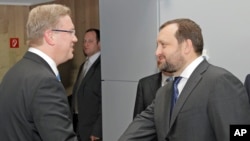 European Commissioner for Enlargement and European Neighborhood Policy Stefan Fuele (l) and Serhiy Arbuzov, Ukrainian Deputy Prime Minister, at the European Commission headquarters in Brussels, Dec. 12, 2013. 