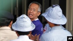 Veera Somkwamkid (C), former leader of Thailand's People's Alliance for Democracy, is escorted by Cambodian police at Phnom Penh Municipal Court, Jan 12, 2011.