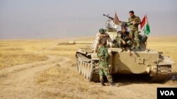 A peshmerga tank crew rests outside Bashiqa, Iraq. (J. Dettmer/VOA)