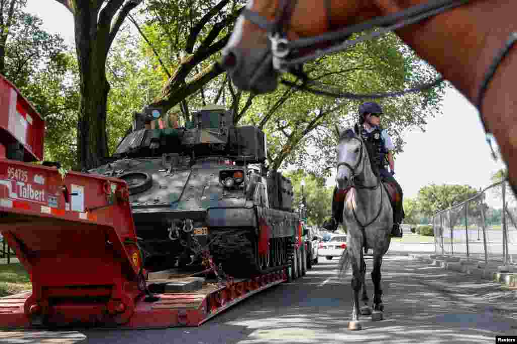 在首都华盛顿，一名美国国家公园骑警经过一辆布雷德利装甲步兵战车。(2019年7月3日)