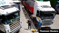 Truck drivers are seen near their parked vehicles as they await test results, amid the spread of the COVID-19 outbreak at the Namanga one-stop border crossing point between Kenya and Tanzania in Namanga, Kenya, May 12, 2020. 