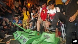Pro-democracy protesters step on the mock Chinese PLA tanks after tens of thousands people march at a down town street during the annual pro-democracy protest in Hong Kong, July 1, 2012. 
