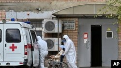 Medical workers wearing protective gear transport a patient suspected of being infected with the coronavirus from an ambulance to a hospital in Rostov-on-Don, Russia, Oct. 22, 2020.