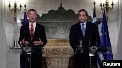NATO Secretary General Jens Stoltenberg (L) addresses journalists alongside Greece's Prime Minister Antonis Samaras during a news conference following their meeting in Athens, Oct. 30, 2014.