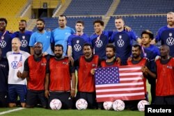 Christian Pulisic of the U.S. and teammates pose with players from a construction workers team on November 15, 2022. (REUTERS/Kai Pfaffenbach)