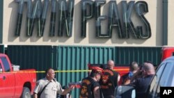 Authorities investigate a shooting in the parking lot of the Twin Peaks restaurant Sunday, May 17, 2015, in Waco, Texas.