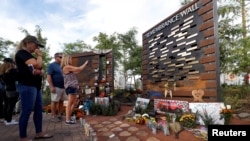 FILE - People look at a Remembrance Wall at the Las Vegas Healing Garden during the one-year anniversary of the mass shooting in Las Vegas, Nevada, Oct. 1, 2018.