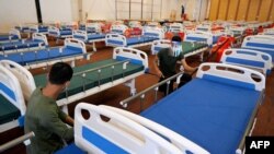 រូបឯកសារ៖ សមាជិកយោធាកម្ពុជារៀបចំគ្រែសម្រាប់អ្នកជំងឺកូវីដ១៩ នៅ​ក្នុងអគារកោះពេជ្រ រាជធានីភ្នំពេញ កាលពីថ្ងៃទី ១១ ខែមេសា ឆ្នាំ ២០២១។ 