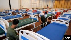 Members of the Cambodian military prepare beds for Covid-19 coronavirus patients at a wedding party hall in Koh Pich that is being turned into a field hospital in Phnom Penh on April 11, 2021. (Photo by TANG CHHIN Sothy / AFP) 