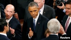 U.S. President Barack Obama gives a thumbs up to Secretary of State John Kerry (R) as he departs after concluding his State of the Union address to a joint session of the U.S. Congress on Capitol Hill, Jan. 20, 2015. 