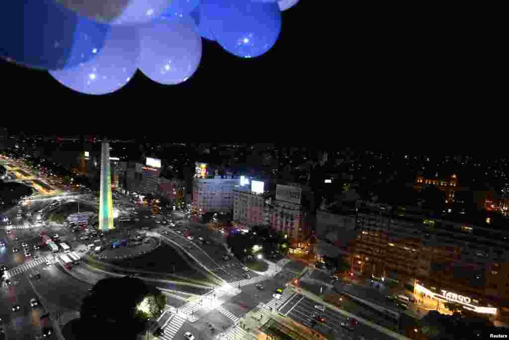 Obelisk disinari warna tim nasional brazil, kuning dan hijau, di Buenos Aires (10/6). Pada saat yang sama, Patung Kristus Penebus di Rio de Janeiro disinari warna putih dan biru dari tim nasional Argentina, untuk menunjukkan persaudaraan kedua negara.&nbsp;(Reuters/Enrique Marcarian)