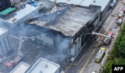 Petugas pemadam kebakaran tengah memadamkan api di pabrik baterai lithium di Hwaseong, Korea Selatan, 24 Juni 2024. (AFP)