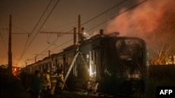 Petugas pemadam kebakaran memadamkan api di sebuah kereta api yang dibakar oleh tersangka anggota milisi paramiliter di Recreio dos Bandeirantes, Rio de Janeiro, Brazil, 23 Oktober 2023. (BRUNO KAIUCA / AFP)