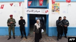 23일 튀니지에서 대선이 치뤄진 가운데, 보안 요원들이 튀니스 투표소 앞을 지키고 서 있다.