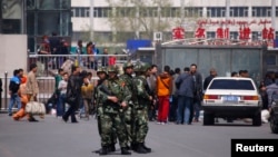 Paramilitary policemen stand guard near the exit of the South Railway Station, where three people were killed and 79 wounded in a bomb and knife attack in Urumqi, Xinjiang Uighur Autonomous region, May 1, 2014.