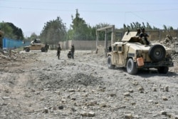 Afghan Security personnel inspect the site of truck suicide bombing in the northern Balkh province of Afghanistan, Aug. 25, 2020.