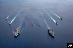 Kapal induk USS Ronald Reagan dan USS Nimitz di Laut China Selatan, 6 Juli 2020. (Foto: via AP)