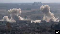In this photo taken from the Turkish side of the border between Turkey and Syria, in Ceylanpinar, Sanliurfa province, southeastern Turkey, smoke and dust billows from targets in Ras al-Ayn, Syria, caused by bombardment by Turkish forces, Oct. 15, 2019.