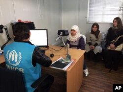 FILE - Biometric identification systems are being used in novel ways. In this photo, a Syrian refugee girl poses for a biometric iris scan in a U.N. office in Amman, Jordan, an intial step in her efforts to be approved for resettlement in the West. Somaliland has become the first to employ iris-scanning technology to identify voters.