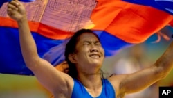 Cambodia's Chov Sotheara celebrates her victory over Thailand's Suree Porn Pimpak to win the gold medal in the women's under 44-kilogram wrestling match at South East Asian Games in Yangon, Myanmar, Friday, Dec 13, 2013. (AP Photo/Gemunu Amarasinghe)