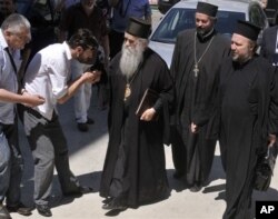 Amfilohije Radović, u sredini, stiže u zgradu suda u Podgorici u junu 2011. godine (Foto: AP)