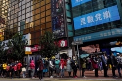 People queue up to purchase face masks outside a shop in Hong Kong, Jan. 27, 2020.